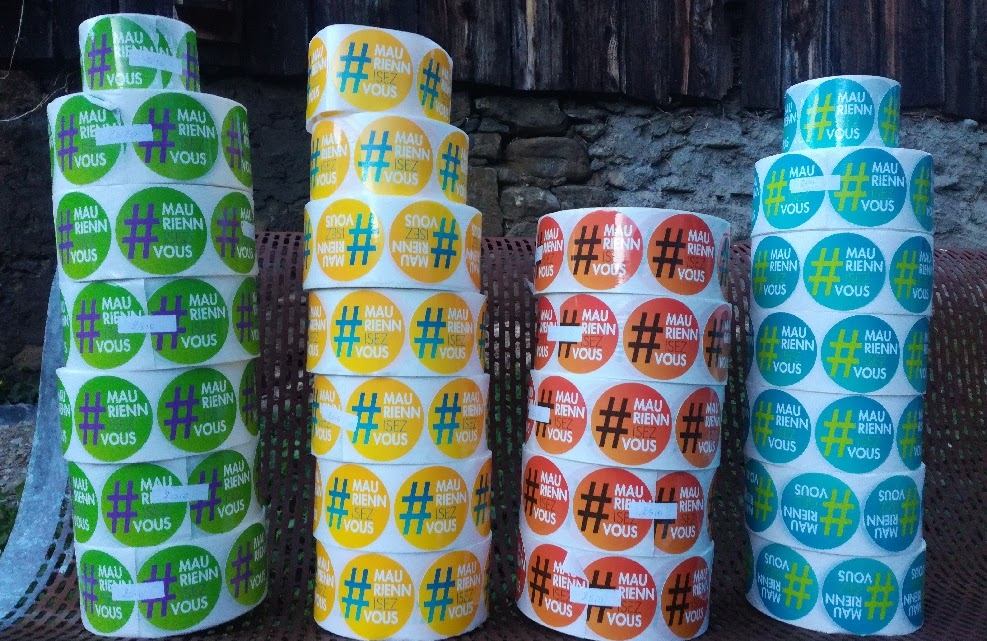 2018, piles de rouleaux d'autocollants #MauriennisezVous de quatre couleurs, prêts à être distribués.