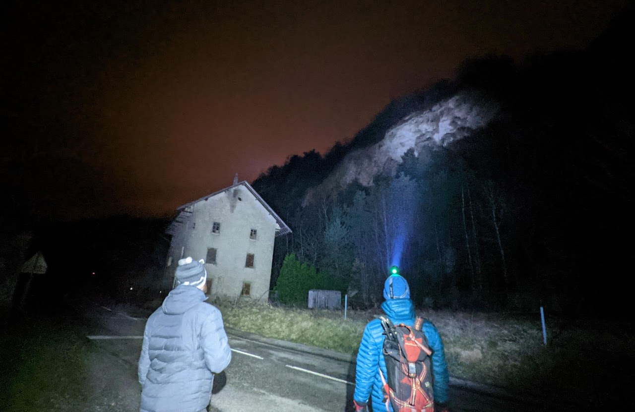 2021, marche nocturne de cohésion : deux membres de l'équipe s'approchent d'un bâtiment isolé et abandonné, éclairé par leurs lampes frontales.