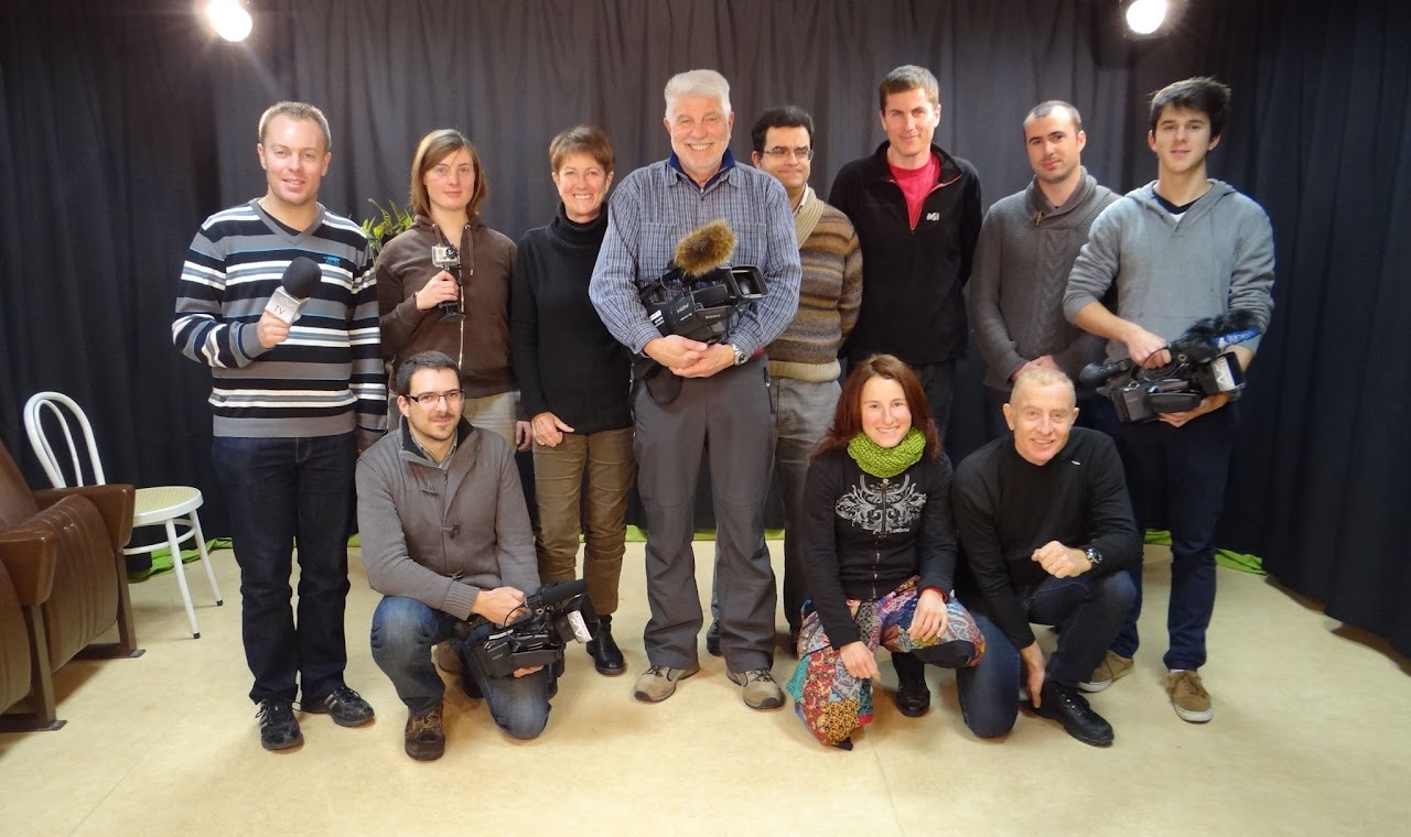 Décembre 2013, photo de groupe de toute l'association devant un fond de scène noir, caméras et micros à la main.