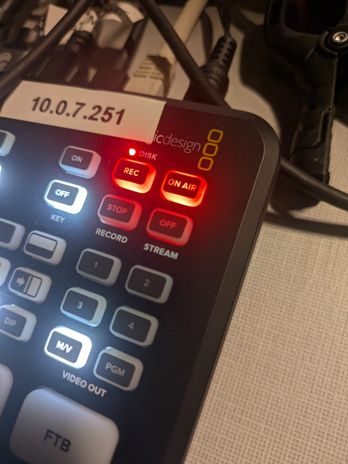 Gros plan du mélangeur Blackmagic ATEM Mini Pro ISO étiqueté 10.0.7.251, boutons REC et ON AIR allumés en rouge pendant la diffusion