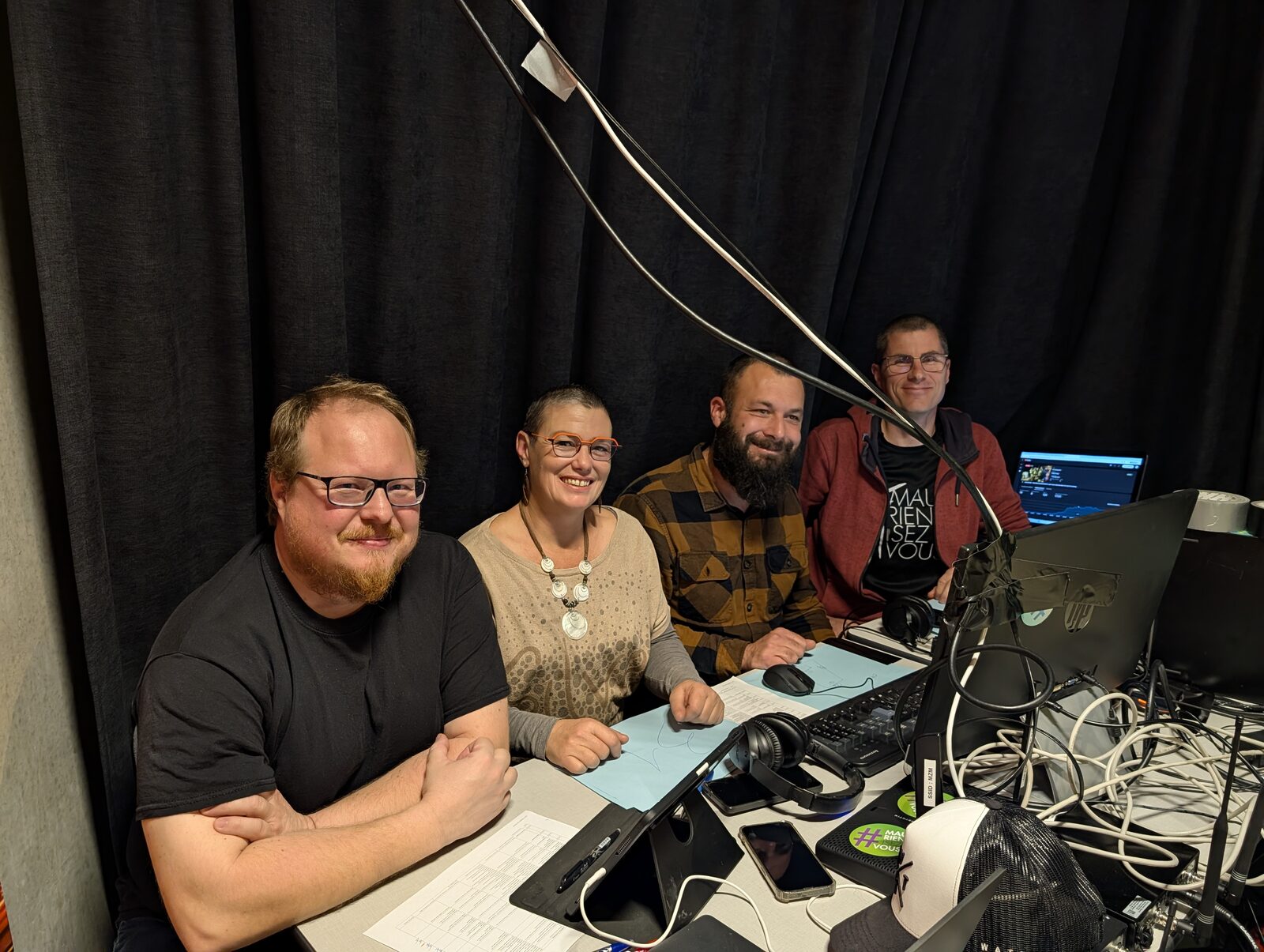 Julian, Katia, Laurent et Alex, l’équipe technique du live Skiogrande, assis derrière la table de régie devant un rideau noir