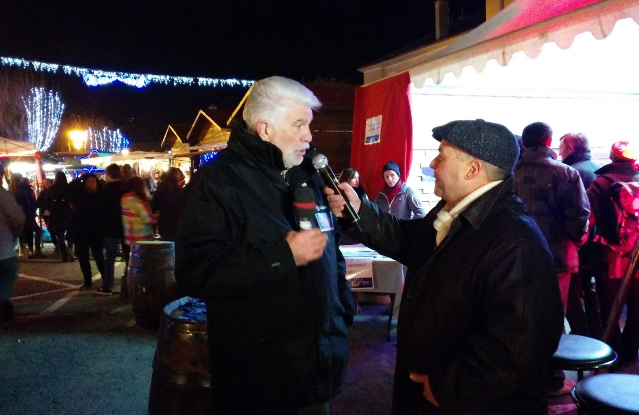 2013, tournage de nuit au marché de Noël de Saint-Jean-de-Maurienne : interview au micro devant les chalets illuminés.