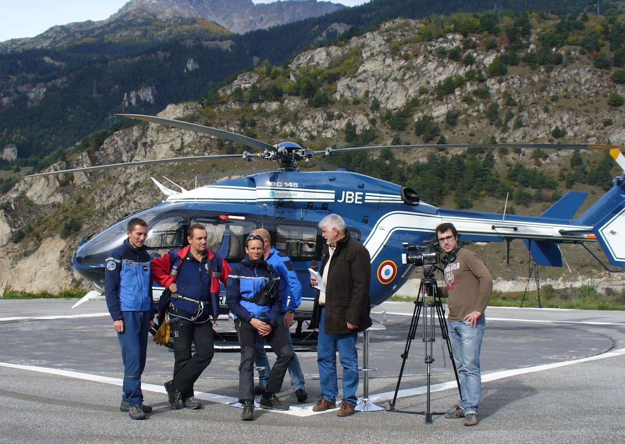 2012, tournage au PGHM : l'équipe de Maurienne TV pose avec des gendarmes de la Peloton de Gendarmerie de Haute Montagne devant un hélicoptère de secours en montagne.