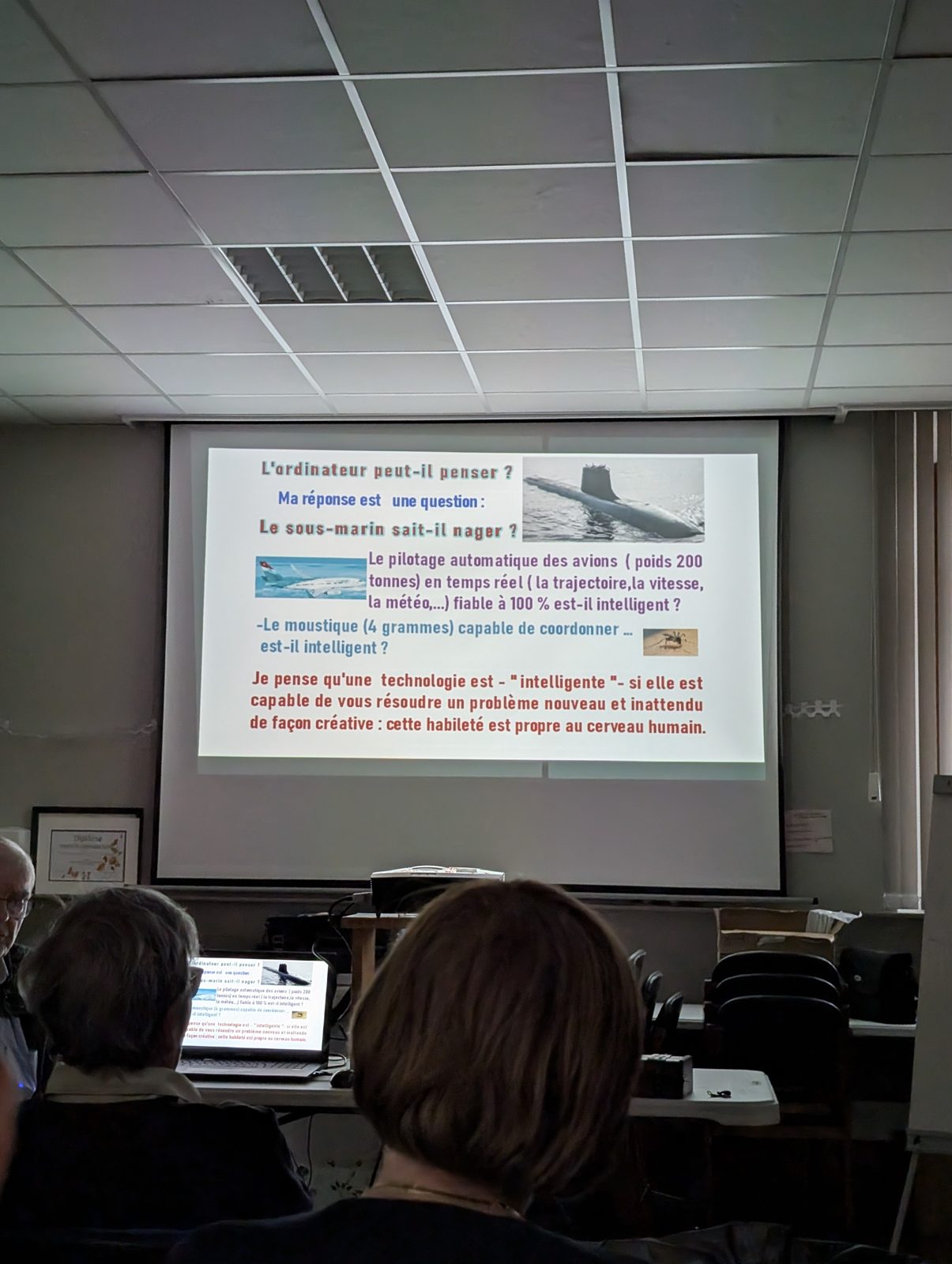 Diapositive projetée : « L'ordinateur peut-il penser ? Le sous-marin sait-il nager ? », avec une photo de sous-marin, d'avion et de moustique