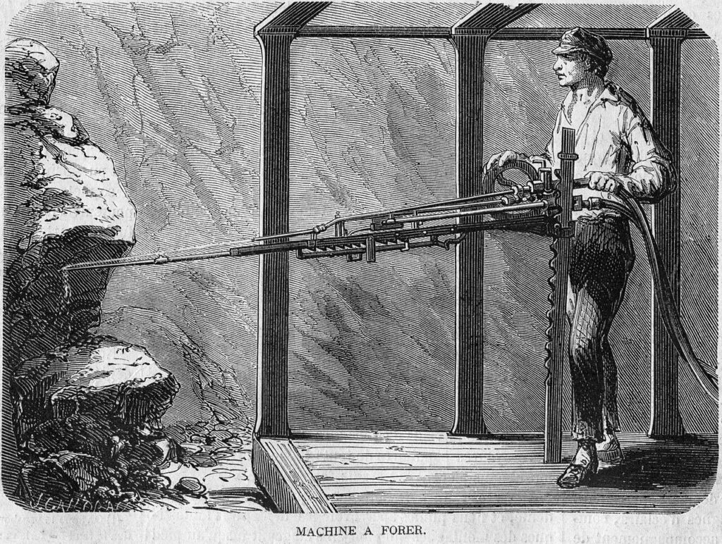 Gravure de 1862 : un ouvrier tient une machine à forer à air comprimé, avec son long fleuret dirigé vers la paroi rocheuse, portée par un bâti métallique