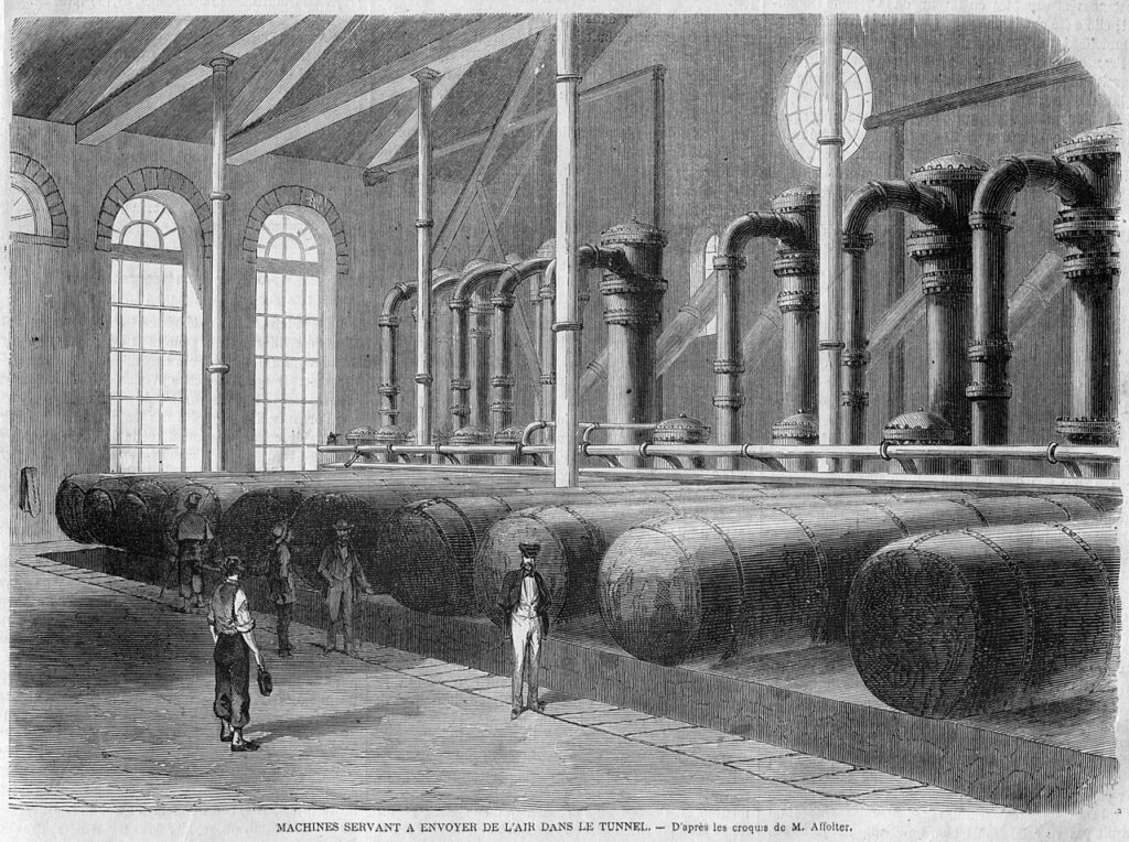 Gravure de 1862 : grande salle des compresseurs avec de gros réservoirs d'air cylindriques couchés au sol, des colonnes et tuyaux recourbés, et quelques visiteurs et ouvriers