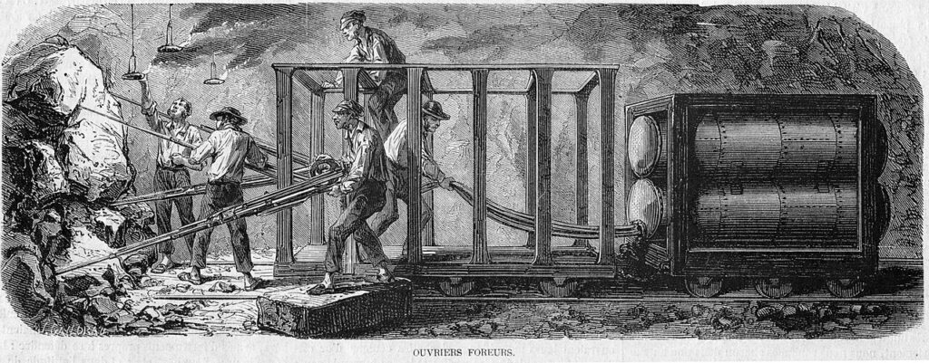 Gravure de 1862 : cinq ouvriers dans la galerie manœuvrent les perforateurs montés sur un chariot, relié par des tuyaux souples à des réservoirs d'air comprimé