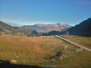 Vue de la webcam du col du Chaussy un matin d'automne : alpage, route du col et sommets de Maurienne sous un ciel bleu